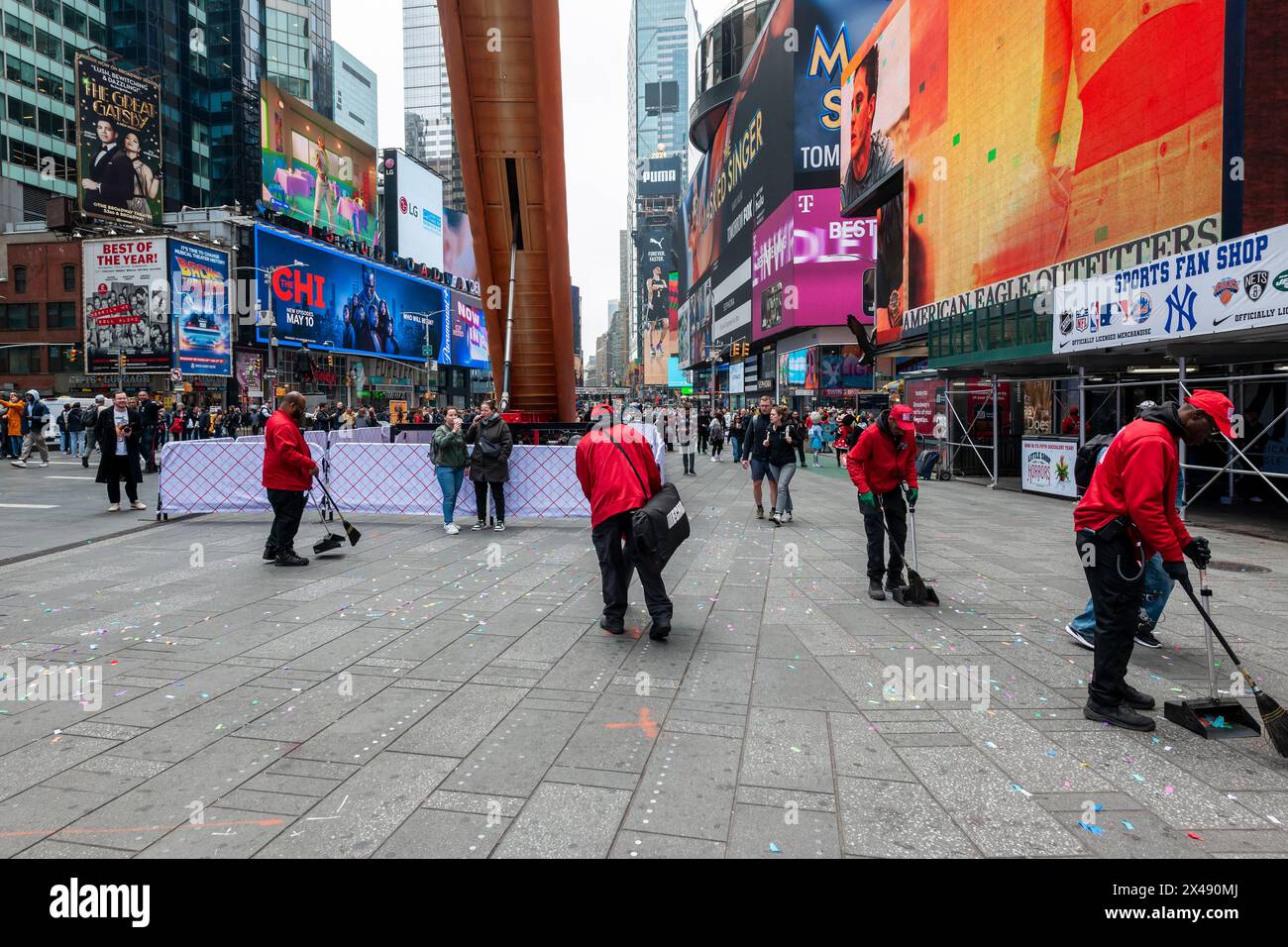 Die Arbeiter der Times Square Alliance räumen am Dienstag, den 30. April 2024, Konfetti aus „Hot Dog in the City“ der Künstler Jen Catron und Paul Outlaw auf dem Times Square in New York auf. Die 65 Meter lange, animatronische Hot Dog-Skulptur hebt sich auf und ejakuliert jeden Tag mittags Konfetti. Die Installation wird bis zum 13. Juni gezeigt. (© Richard B. Levine) Stockfoto