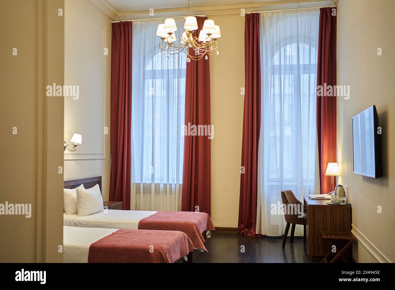 Zwei Betten in einem Hotelzimmer in einem Touristenresort. Das Innere des Doppelzimmers ist in einem modernen minimalistischen Stil mit rotem Dekor und Platz zum Kopieren. Hochwertige Fotos Stockfoto