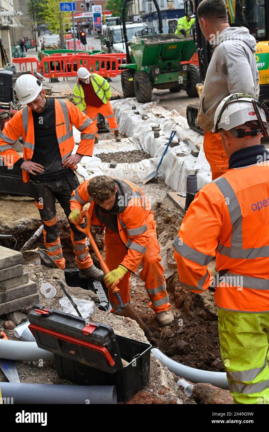 Openreach-Arbeiter graben Graben am Straßenrand zur Installation von Glasfaserkabeln für Breitband- und Telefonleitungen, Großbritannien Stockfoto