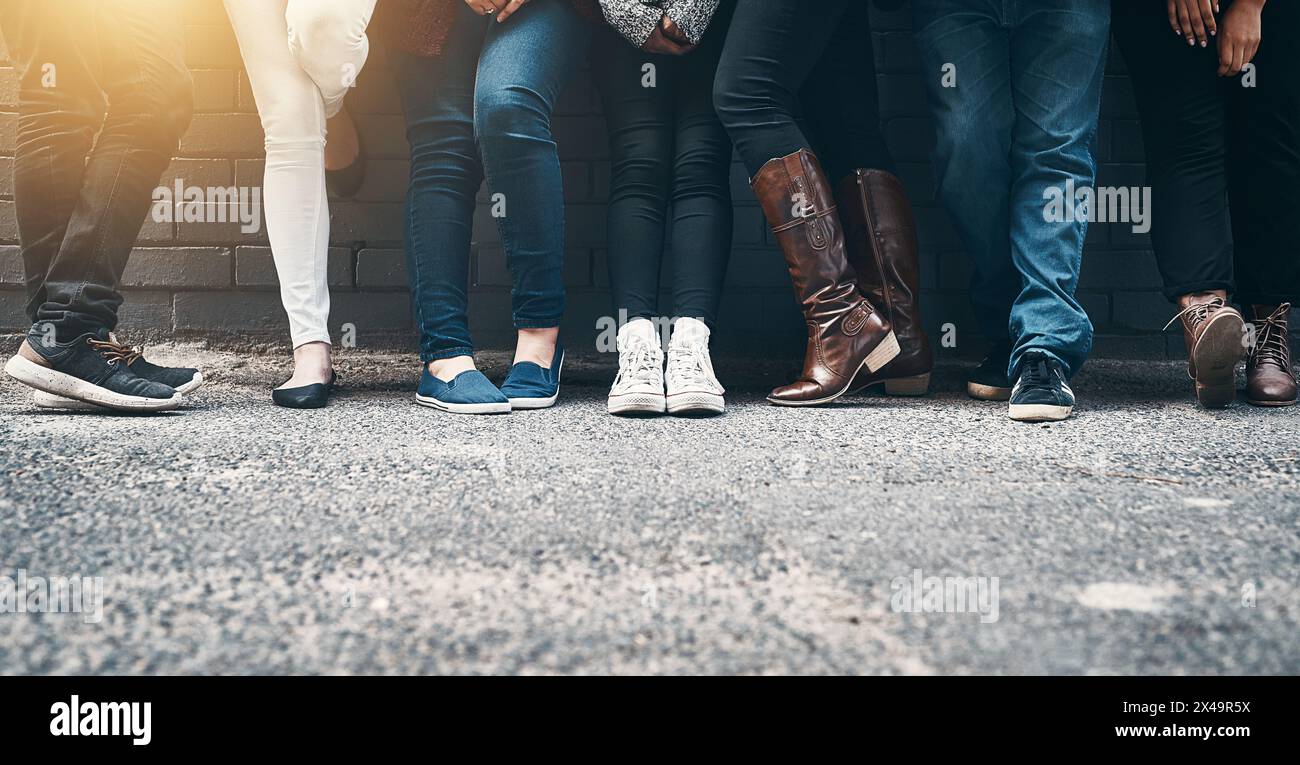 Im Freien, Beine und Personen in Reihe an der Wand während der Wartezeit, Termin und Schlange für die Registrierung. Füße, Schuhe und Schuhe der Menge für die Abstimmung Stockfoto