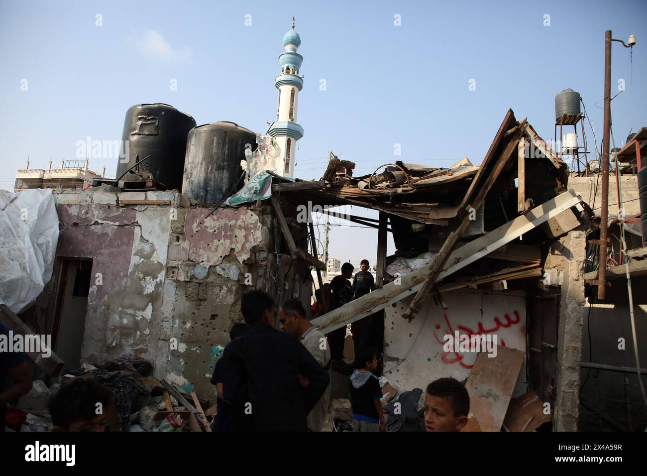 Gaza. Mai 2024. Am 1. Mai 2024 inspizieren Menschen ein zerstörtes Haus im südlichen Gazastreifen in Rafah. Die Zahl der palästinensischen Todesopfer aufgrund der laufenden israelischen Angriffe auf den Gazastreifen ist auf 34.568, so die von der Hamas betriebenen Gesundheitsbehörden am Mittwoch in einer Pressemitteilung. Quelle: Khaled Omar/Xinhua/Alamy Live News Stockfoto