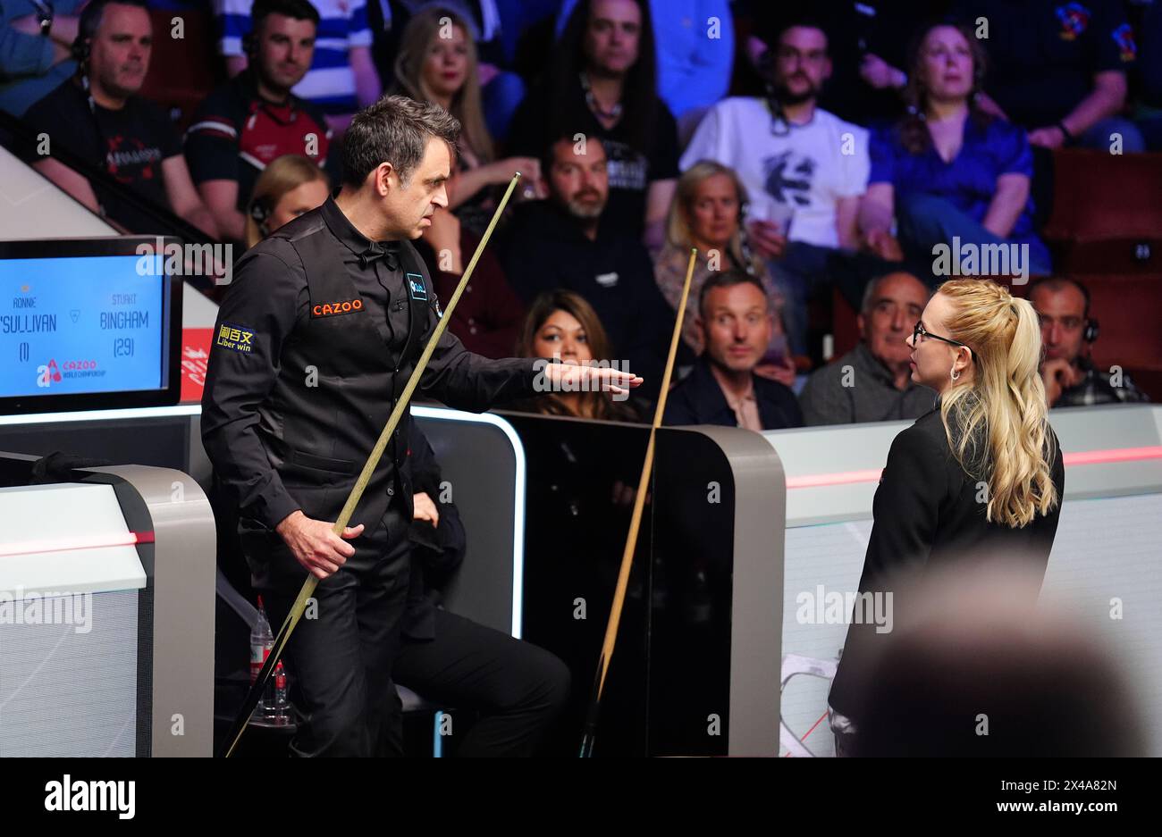 Ronnie O’Sullivan (links) spricht mit Schiedsrichter Desislava Bozhilova (rechts) während einer Spielpause, da einige Mitglieder der Menge noch im Viertelfinalspiel gegen Stuart Bingham am 12. Tag der Cazoo World Snooker Championship 2024 im Crucible Theatre in Sheffield auf ihre Plätze kamen. Bilddatum: Mittwoch, 1. Mai 2024. Stockfoto