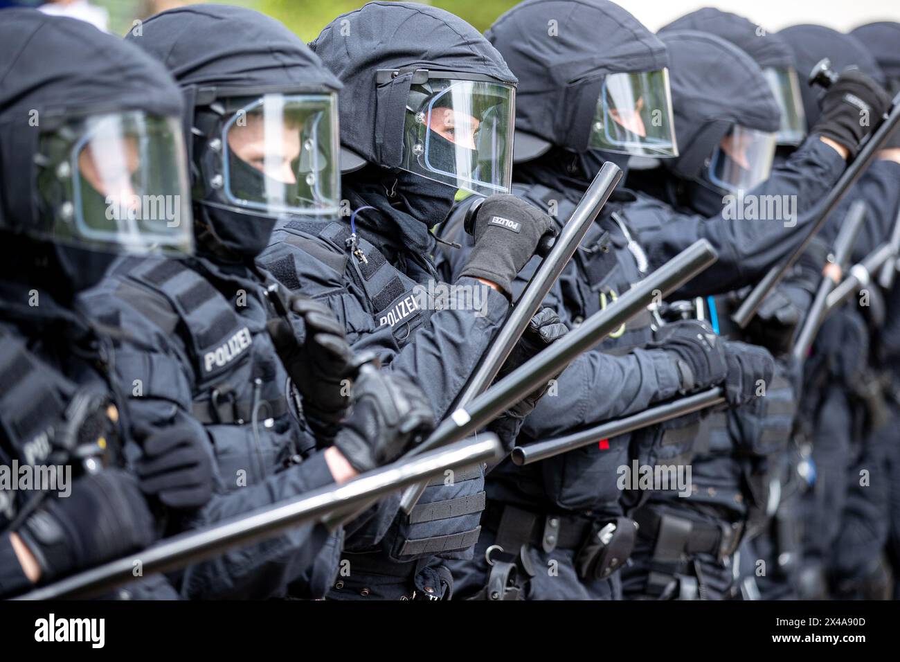 Eft Hellendorf, Deutschland. Mai 2024. Die Polizeikräfte aus Kirkel bilden eine Verteidigungslinie mit Schutzausrüstung, Helmen und Schlagstöcken im Rahmen der Homeland Security-Übung des National Guardian 2024. Bei dieser Übung wird die Sicherung und der Schutz eines Munitionsversorgungszentrums geübt. Während der Bundeswehr-Übung üben die Heimatschutzkräfte in ganz Deutschland ihre Kernaufgabe aus, wichtige Verteidigungsinfrastrukturen zu schützen und zu sichern. Quelle: Laszlo Pinter/dpa/Alamy Live News Stockfoto