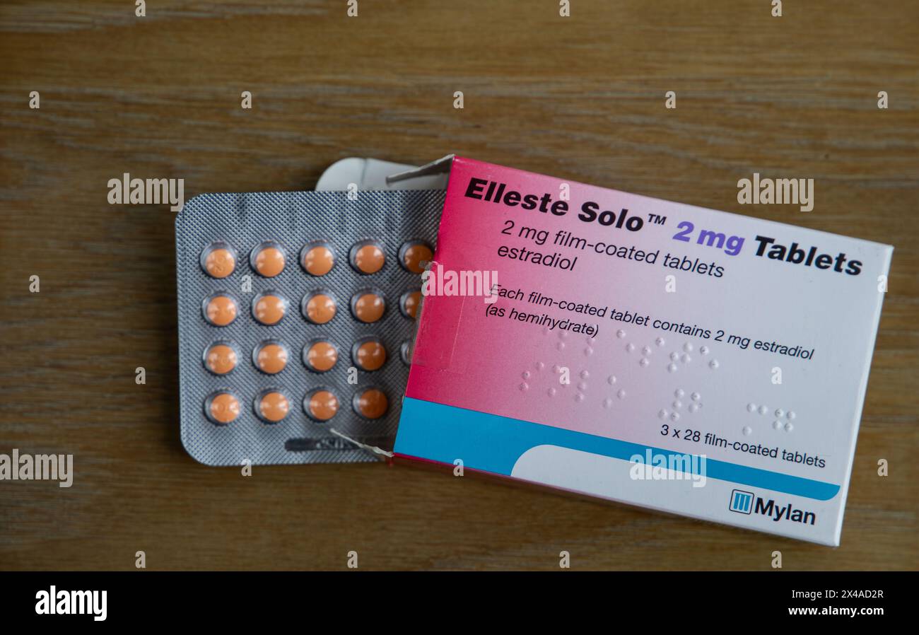 Blisterpackung mit Elleste Solo 2 mg Tabletten zusammen mit der Verpackung auf einer Holzoberfläche Stockfoto