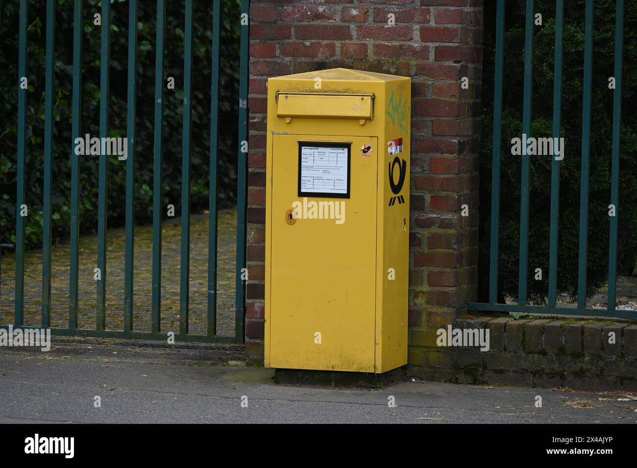 Ein gelber Briefkasten der deutschen Post am Strassenrand *** Ein gelber Briefkasten der deutschen Post am Straßenrand Stockfoto