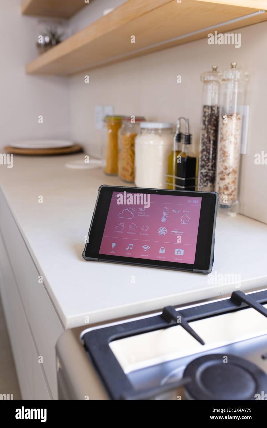 Ein Tablet mit Smart Home-Schnittstelle steht zu Hause auf einer Küchenzeile Stockfoto