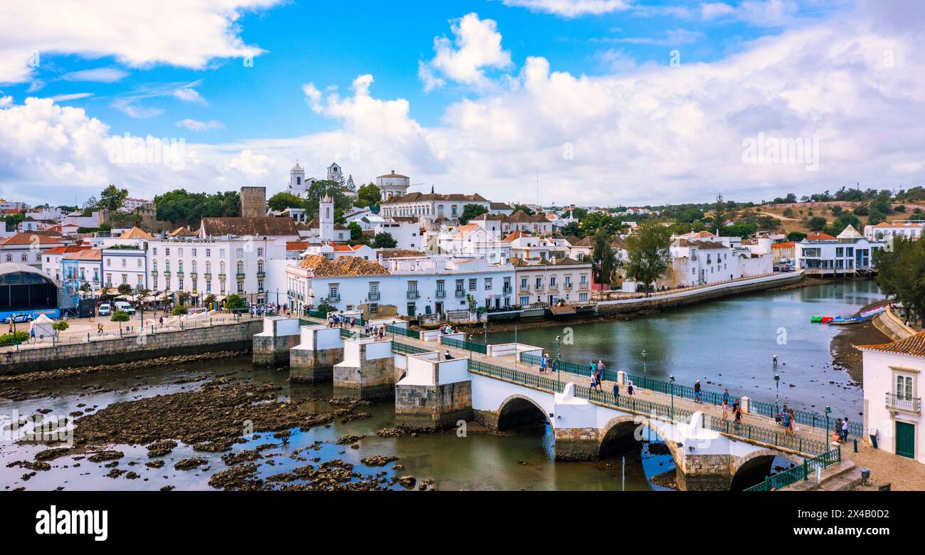 Blick auf die historische Stadt Tavira mit römischer Brücke über den Fluss Gilao, Algarve, Portugal. Stadtbild der Altstadt von Tavira mit Uhrturm, St. Marys Chu Stockfoto