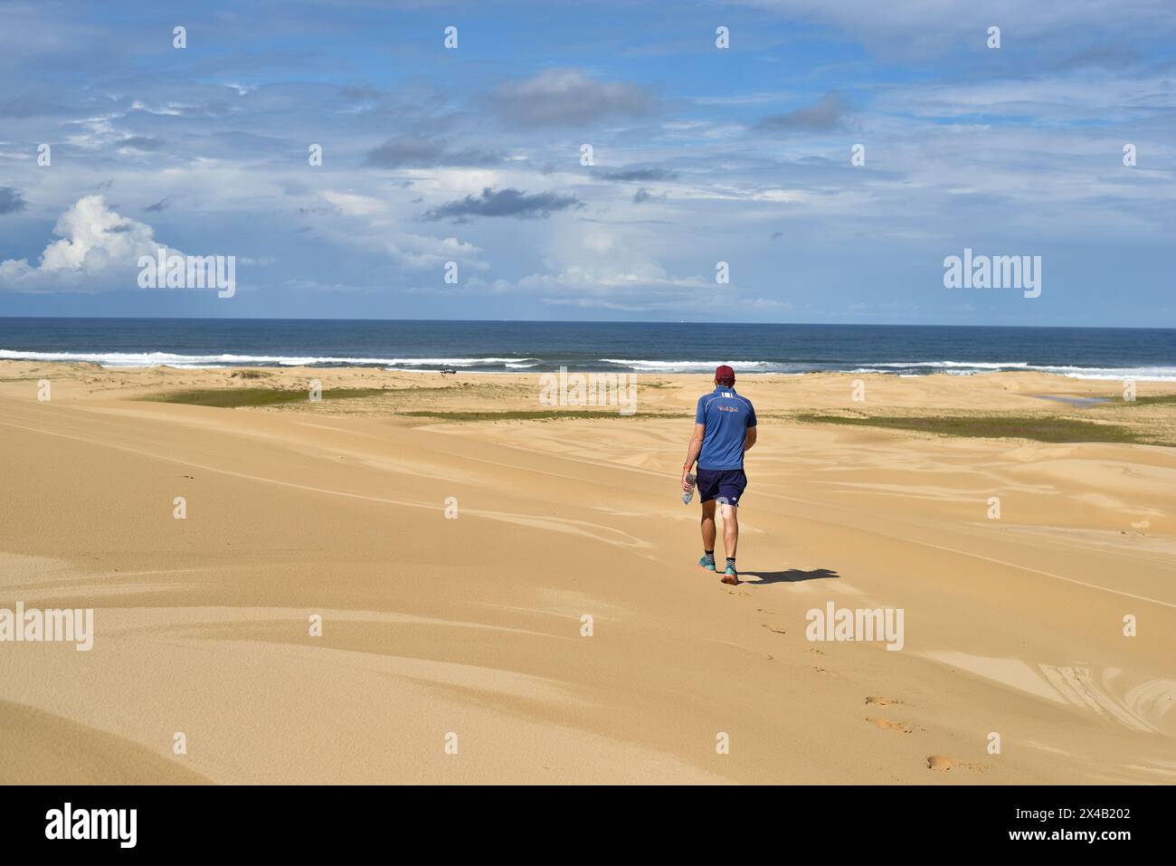 Mann, der durch weite Sanddünen läuft Stockfoto