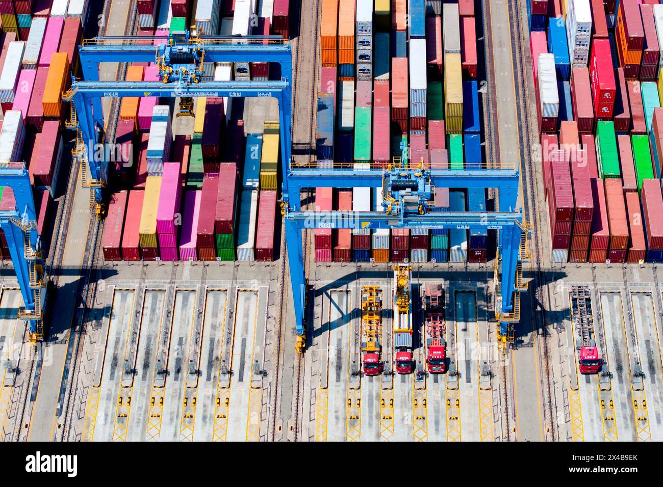 QINGDAO, CHINA - 1. MAI 2024 - im automatisierten Terminal des Hafens Qingdao transportiert ein fahrerloser Tieflader Container vom Terminal in den Behälter Stockfoto QINGDAO, CHINA - 1. MAI 2024 - im automatisierten Terminal des Hafens Qingdao transportiert ein fahrerloser Tieflader Container vom Terminal in den Behälter Stockfoto