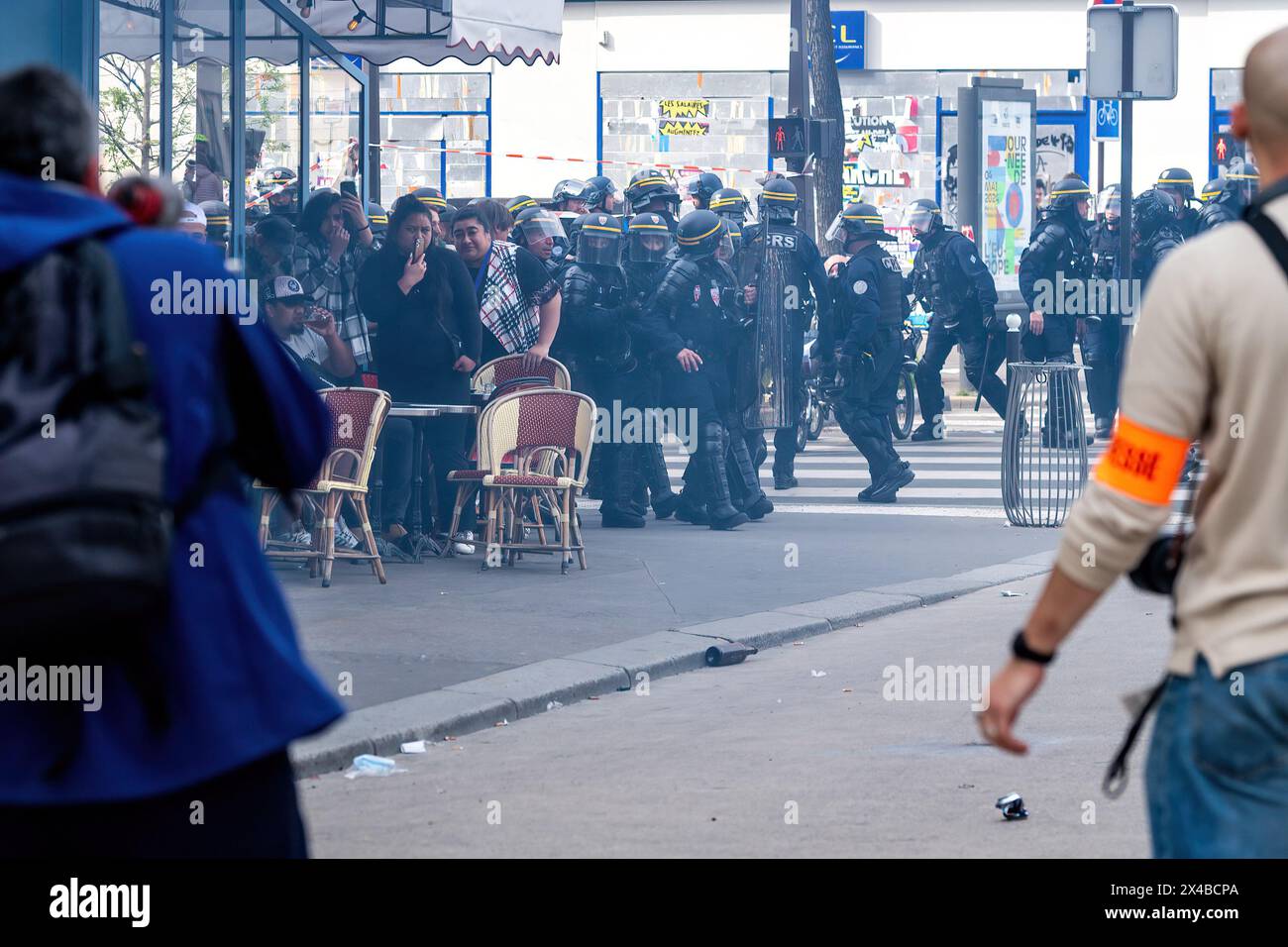 Touristen suchen nach Deckung, während die Polizei und Demonstranten während des jährlichen marsches zum Internationalen Arbeitertag in Paris am 1. Mai, dem Tag des 1. Mai, in der Nation zusammenstoßen. Während der Proteste im Mai lauern die Pariser Straßen mit Feuerwerken und Stuntgranaten, während die Arbeiter ihre Rechte in einem Meer von Spruchbändern und Gesängen behaupten. Inmitten der Inbrunst brechen Zusammenstöße zwischen Demonstranten und Aufstandspolizisten aus, Tränengas füllt die Luft, während die Spannungen eskalieren. Die Veranstaltung unterstreicht den anhaltenden Kampf für Arbeitnehmerrechte und soziale Gerechtigkeit, während Aktivisten sich in einem kollektiven Aufruf zum Wandel auf den Straßen der französischen Hauptstadt vereinen. Stockfoto