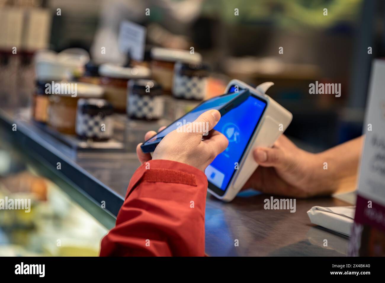 Kontaktloses Bezahlen per Mobiltelefon auf einem Markt Stockfoto