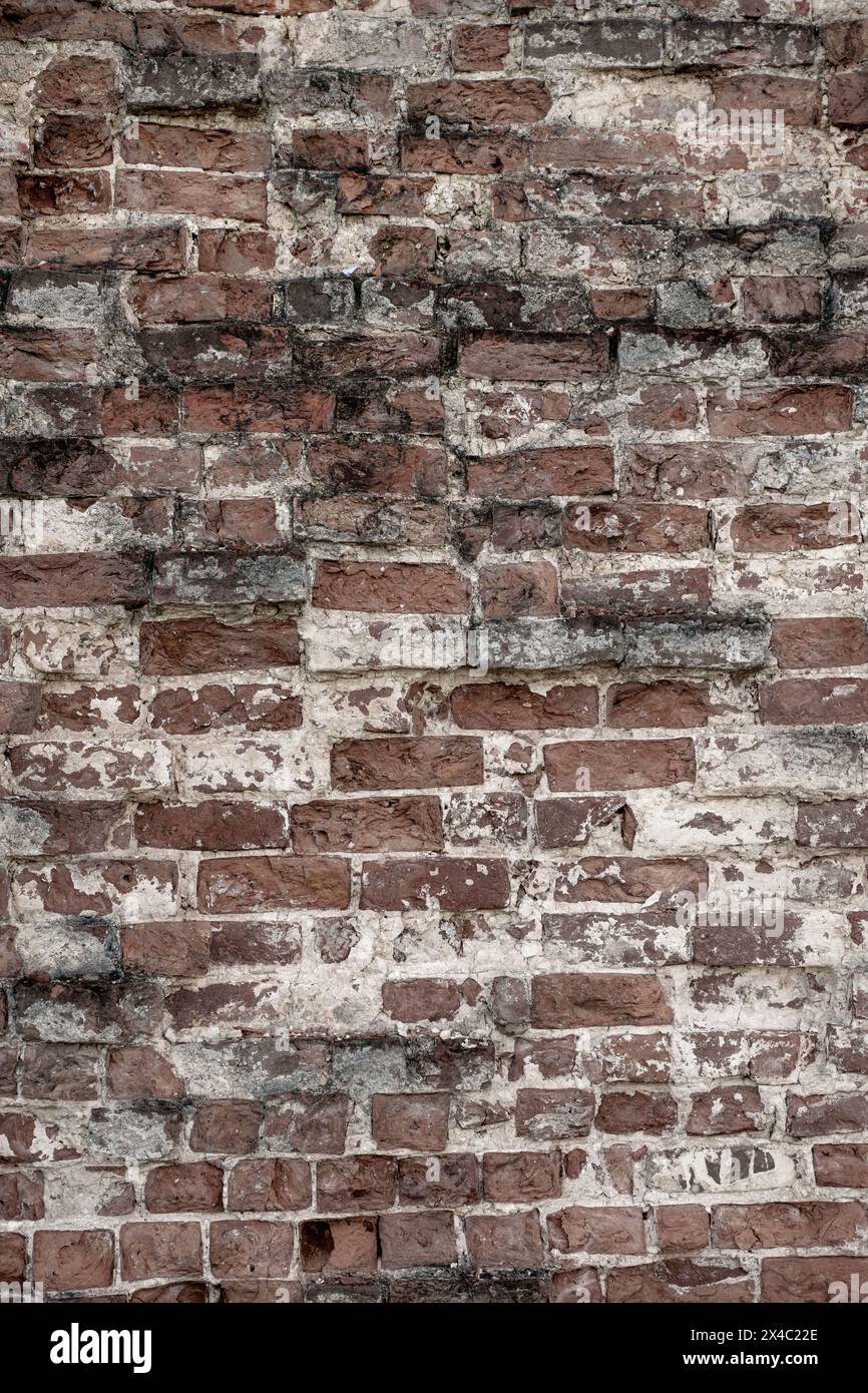 Eine alte Ziegelmauer. Antiker roter Backsteinhintergrund mit weißer Zwischenschicht zwischen Ziegeln. Vertikales Foto. Hochwertige Fotos. Kann für Bannerdesign und Werbematerialien verwendet werden. Stockfoto