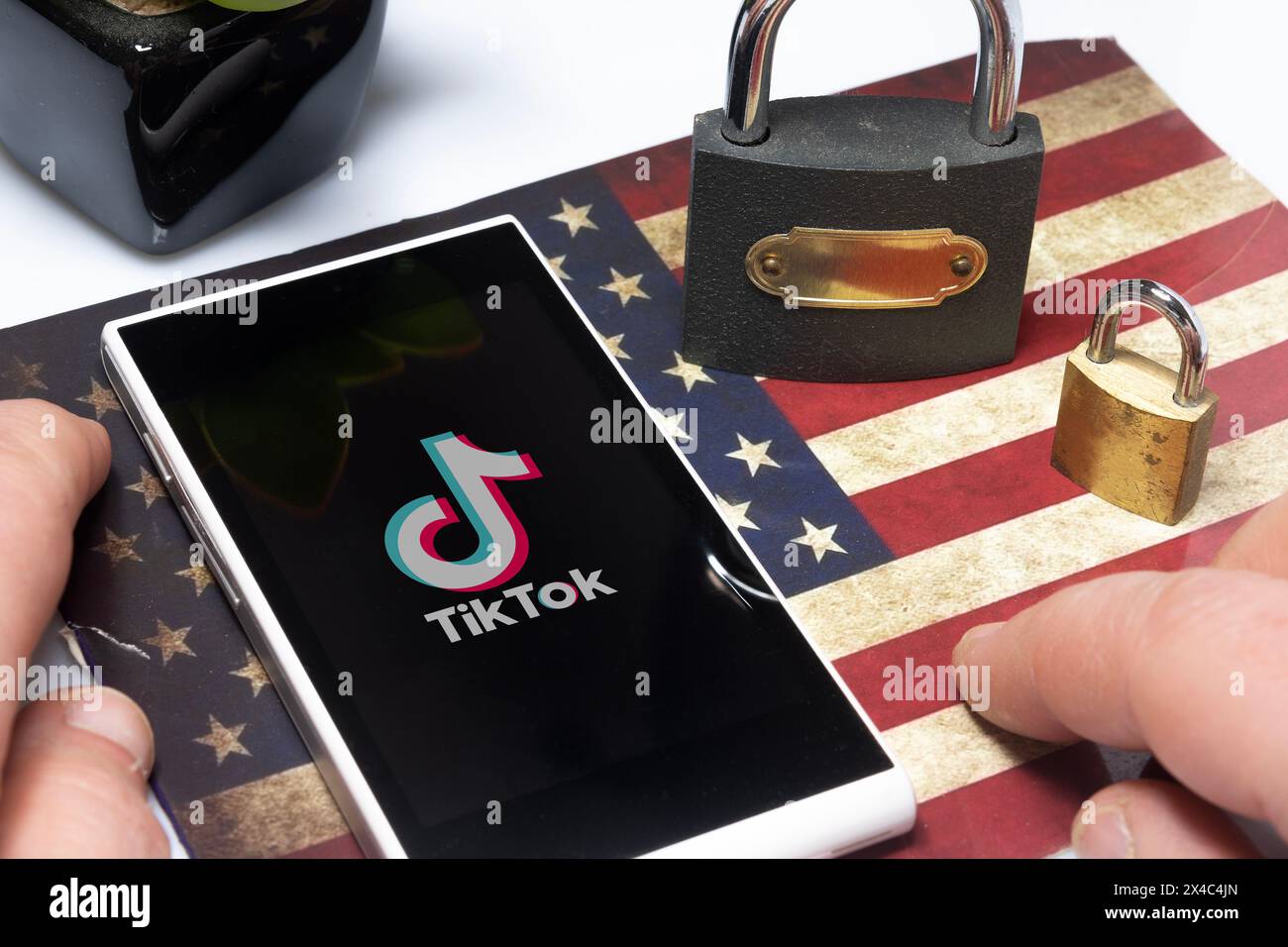 Carrara, Italien - 02. Mai 2024 - TikTok Ban Concept: Smartphone über einer US-Flagge mit einigen Schlössern und dem tiktok-Logo Stockfoto