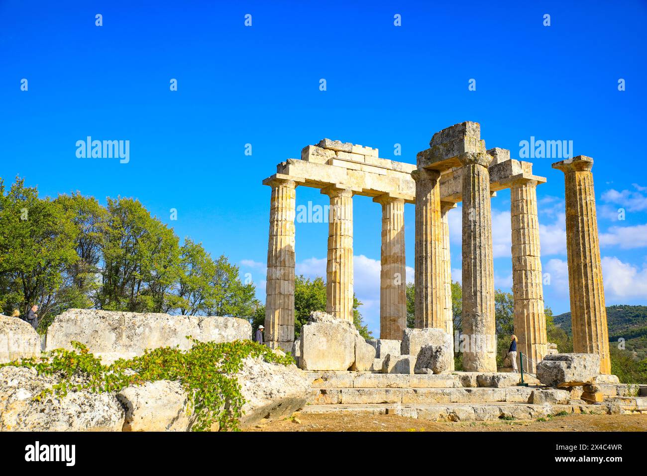Nemea, Griechenland. Antike Stadt Nemea dorische Tempelsäulen und mehrere Touristen Stockfoto