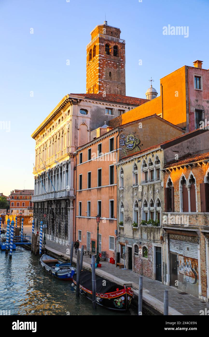 Venedig, Italien. Die Sonne erwärmt den Campanella-Turm und einen venezianischen Bootskanal Stockfoto