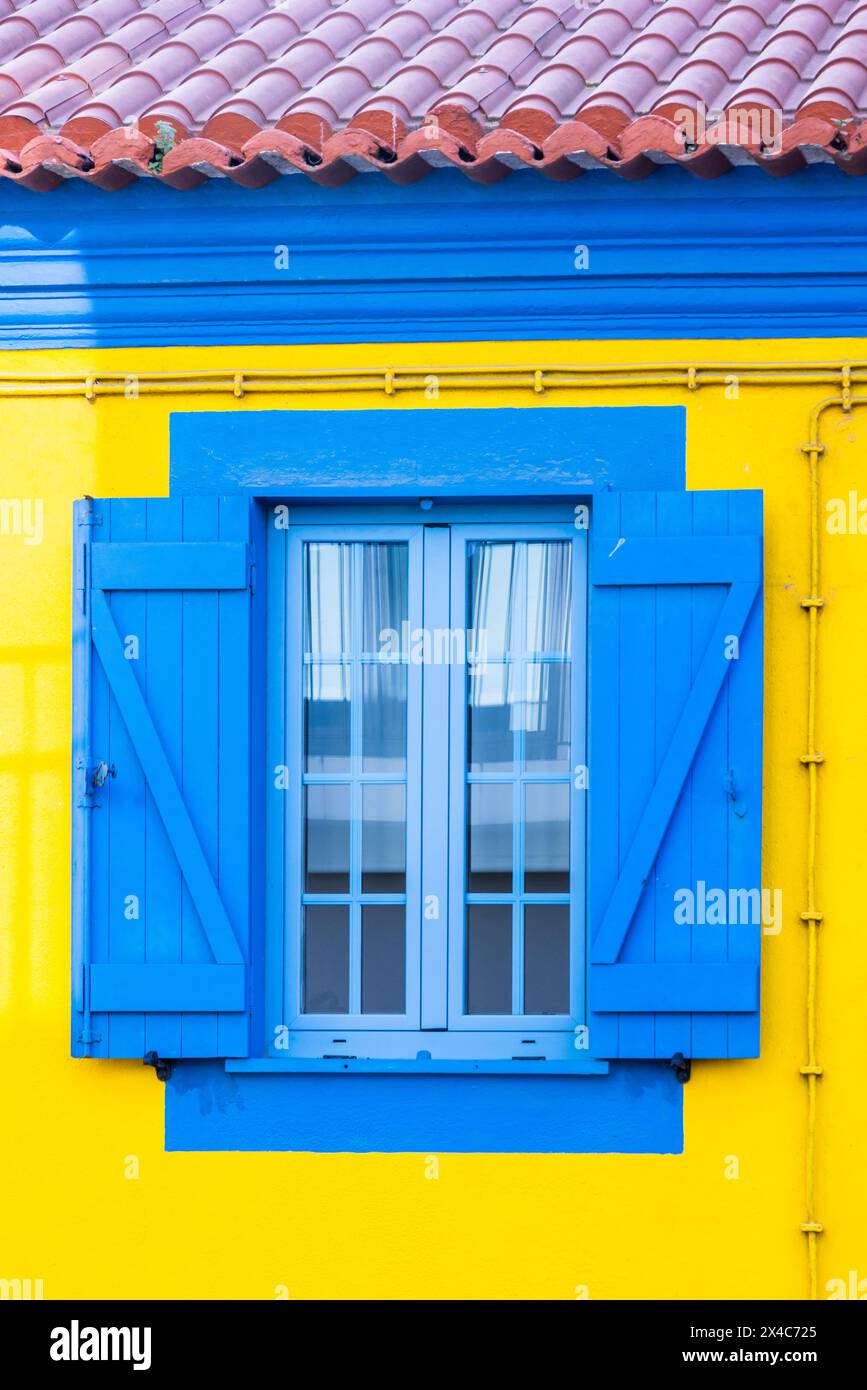 Portugal, Aveiro. Hellblaues Fenster auf einem gelben Gebäude. Stockfoto