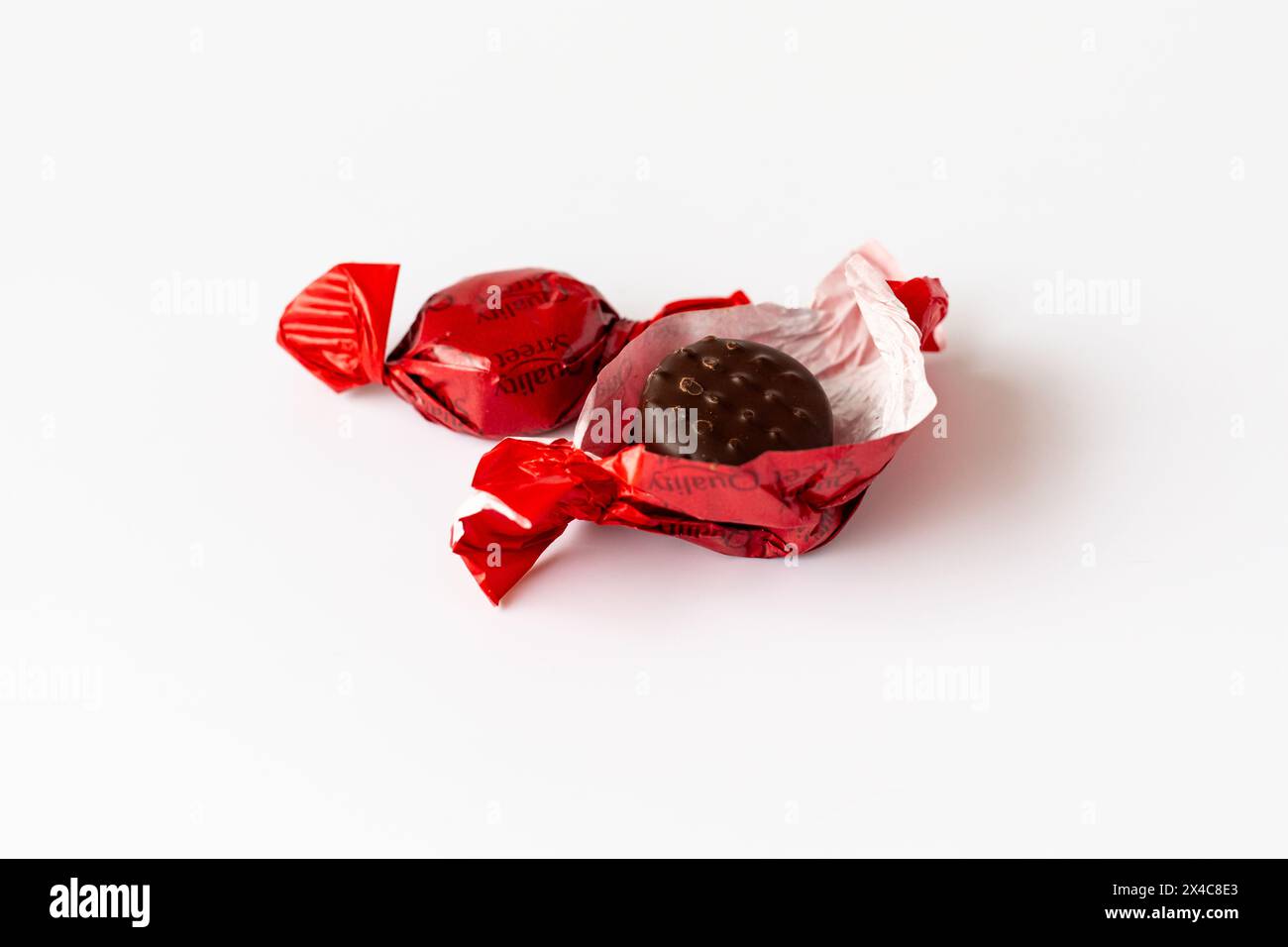 Zwei Street Sweets mit Erdbeergeschmack in den neuen recycelbaren Papierverpackungen, eine wurde geöffnet und zeigt die Schokoladensüße. Stockfoto