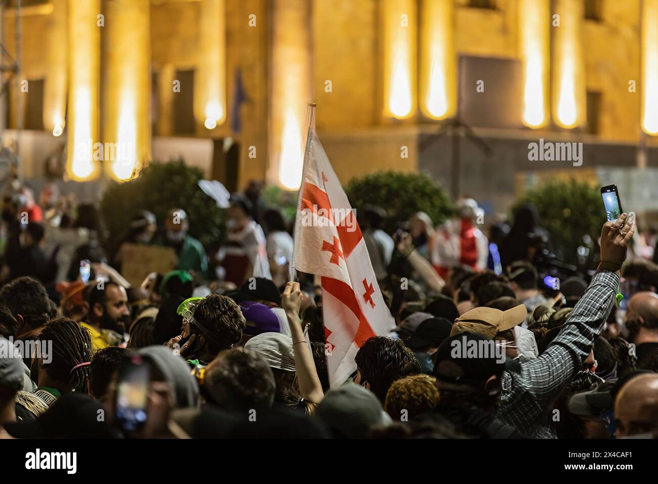 Tiflis, Georgien. Mai 2024. Während einer Demonstration vor dem georgischen Parlament wird eine georgische Flagge unter einer Menge von Demonstranten hoch gehalten. Tausende haben an einem Protest gegen die zweite Lesung eines Gesetzes teilgenommen, das zur Vornahme eines umstrittenen Gesetzes über "ausländische Agenten" gestimmt wurde, das wochenlange Massenproteste in der Hauptstadt Tiflis ausgelöst hat. (Foto: Nicholas Müller/SOPA Images/SIPA USA) Credit: SIPA USA/Alamy Live News Stockfoto