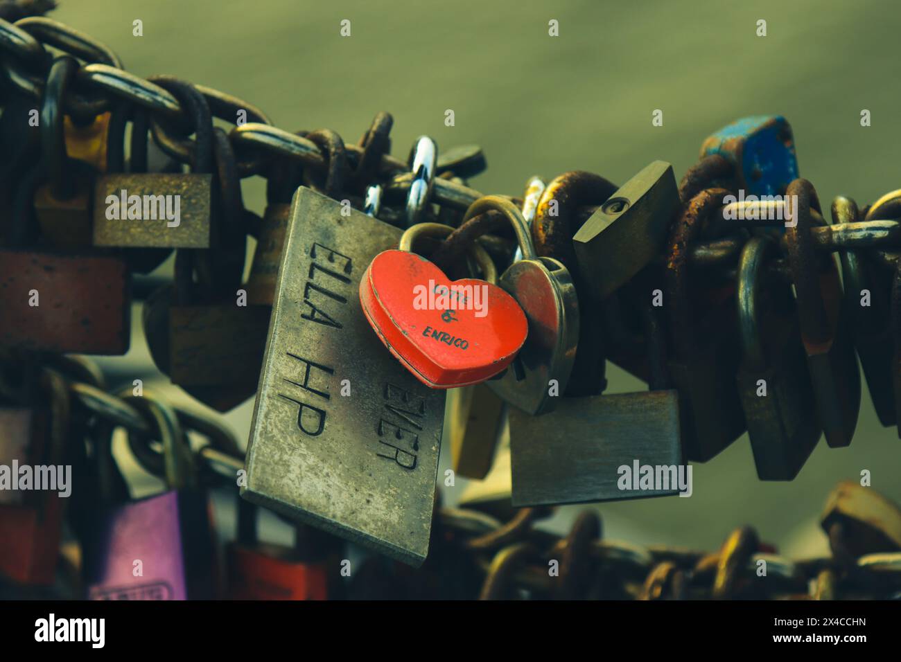 Ein herzförmiges Schloss symbolisiert eine unzerbrechliche Verbindung und ziert eine Brücke, die die dauerhafte Liebe zwischen zwei Seelen verkörpert. Stockfoto