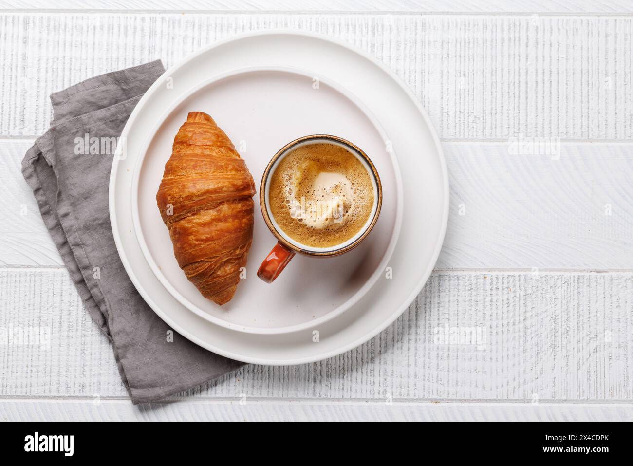 Cappuccino-Kaffee und frisches Croissant auf Holztisch. Flache Ladefläche mit Kopierraum Stockfoto