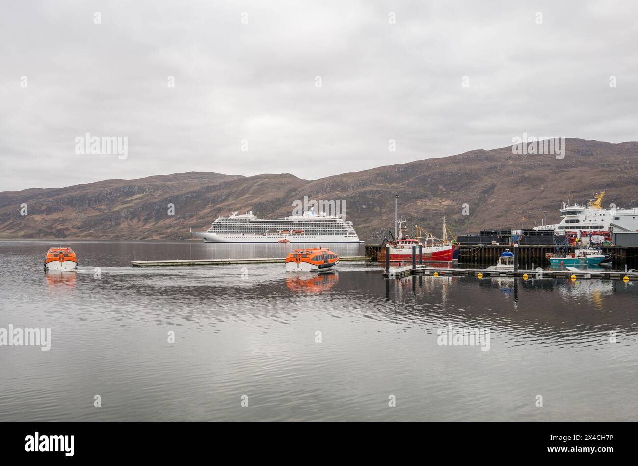 Das Viking Saturn ankerte vor der schottischen Küstenfischerstadt Ullapool und mit Rettungsbooten, die Passagiere befördern. Stockfoto