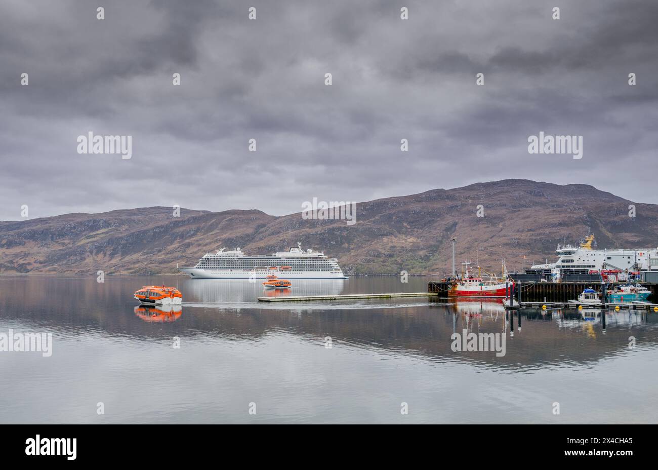 Das Viking Saturn ankerte vor der schottischen Küstenfischerstadt Ullapool und mit Rettungsbooten, die Passagiere befördern. Stockfoto