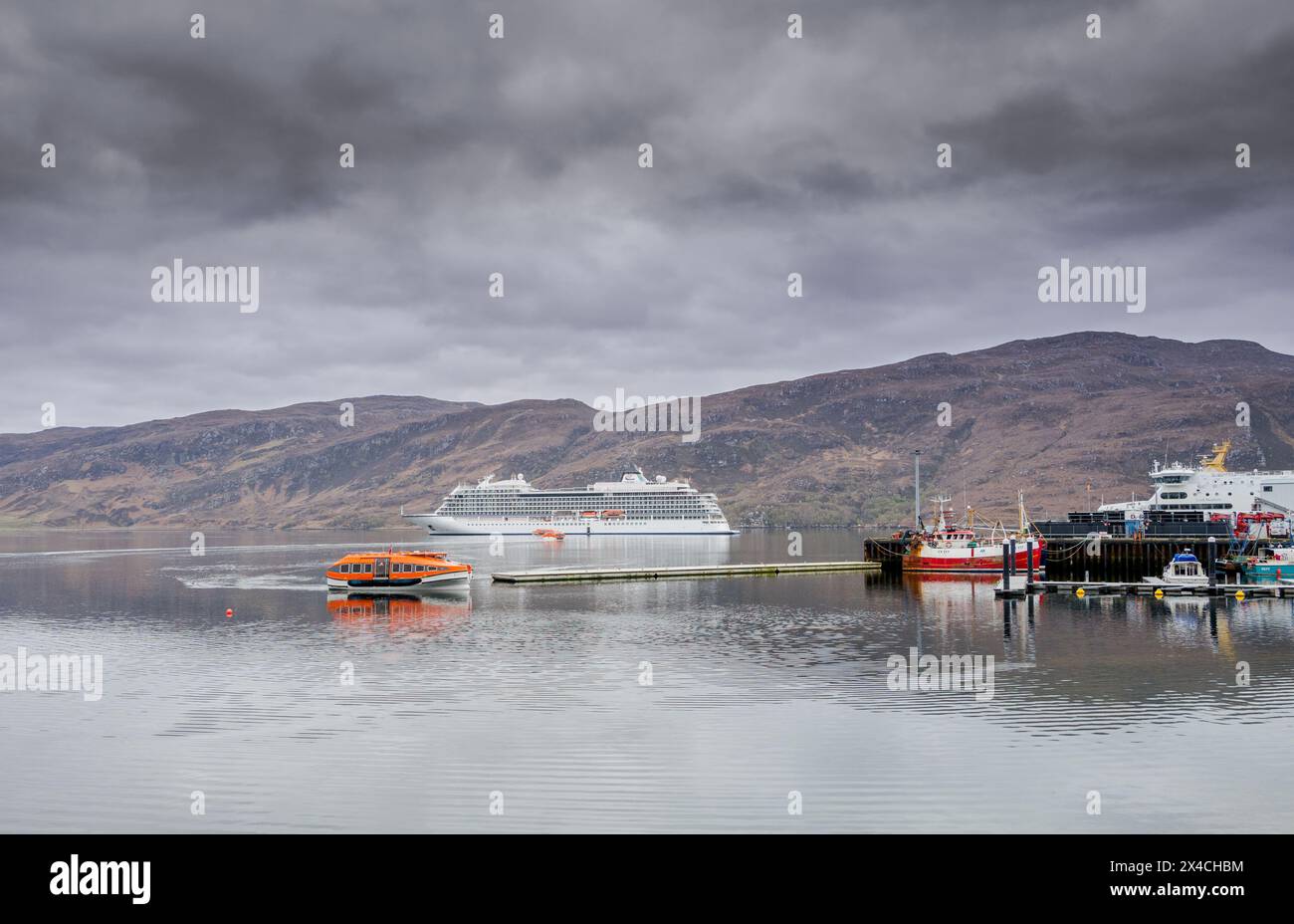 Das Viking Saturn ankerte vor der schottischen Küstenfischerstadt Ullapool und mit Rettungsbooten, die Passagiere befördern. Stockfoto