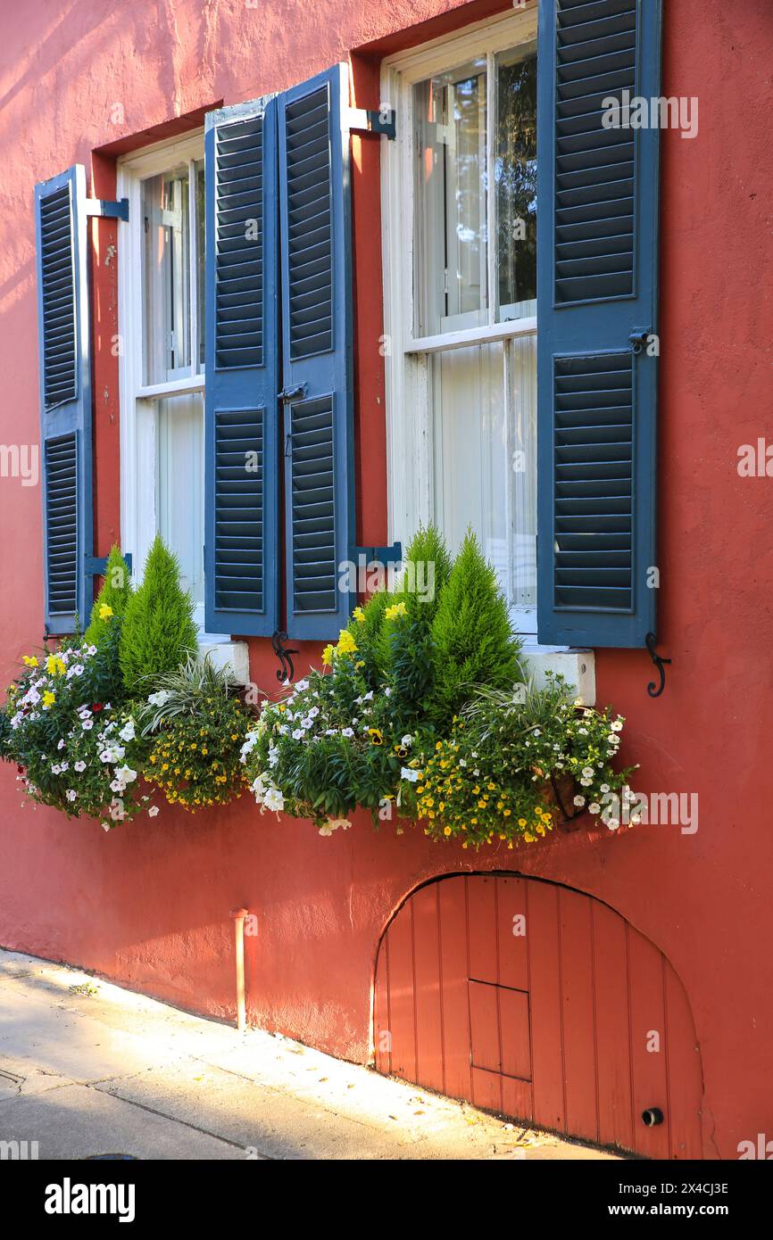 Charleston, South Carolina, USA. Rotes historisches Haus mit Plantagenläden und blühenden Blumenkästen Stockfoto