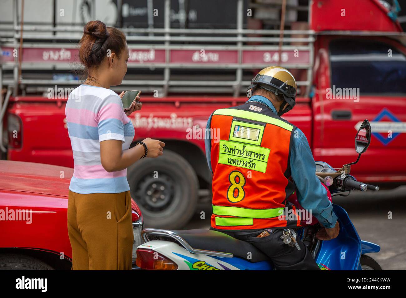 Bangkok, Thailand - 5. März 2024: Eine unbekannte Frau mit Motorradtaxi in Bangkok, Thailand. Stockfoto