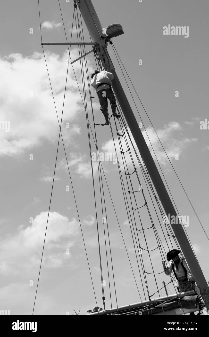 Pirate klettert auf den Mast eines großen Schiffes, das am Flussufer in Georgetown, South Carolina, angedockt ist. Stockfoto