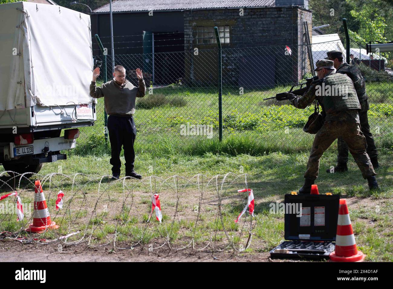 Darstellung: Soldaten bewachen einen Verdaechtigen, Soldaten ueberpruefen einen LKW in der Fahrzeugschleuse, allgemein, Feature, Randmotiv, Symbolfoto Kontrollposten, Checkpoint, Bundeswehr-Uebung AGILES ROSS im Rahmen der bundesweiten Uebung LANDESVORMUND, die nordrhein-westfaelischen Heimatschutzkraefte des Heimatschutzregiments 2 aus Münster uebenin der Wahner Heide bei Troisdorf Altenrath, 02.05.2024, *** Abbildung Soldaten, die einen Verdächtigen bewachen, Soldaten, die einen LKW im Fahrzeugschloss kontrollieren, allgemein, Merkmal, Grenzmotiv, symbolischer Fotokontrollpunkt, Checkpost, Bundeswehrübung AGI Stockfoto