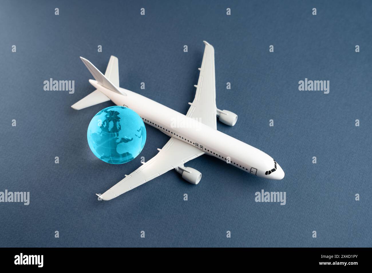 Flugzeug und blauer Globus. Bau neuer Flugplätze. Entwicklung der Zivilluftfahrt. Reise- und Geschäftsreisen. Verkehrssystem und Infrastruktur. Stockfoto