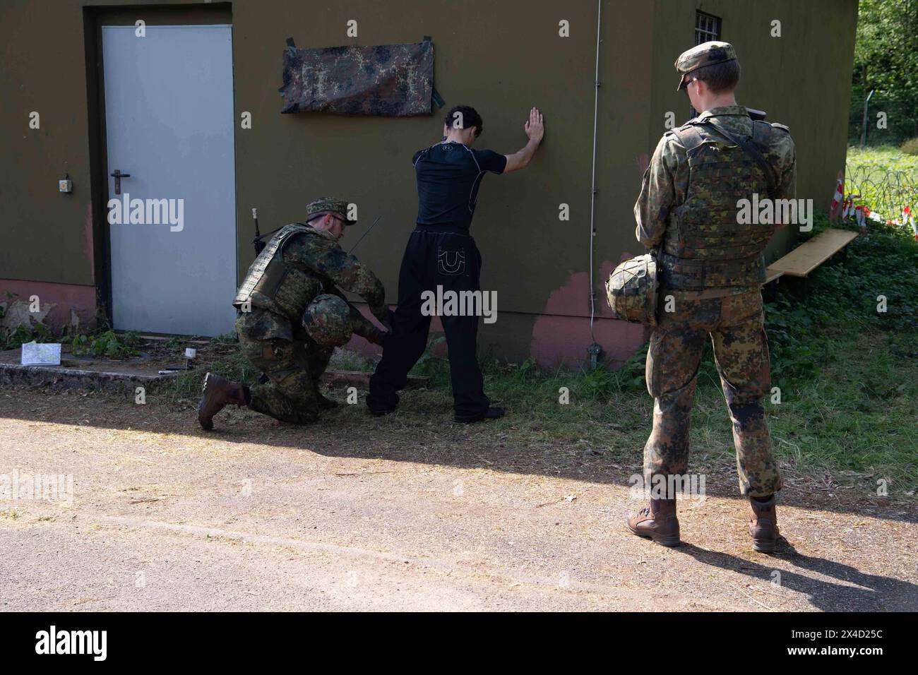 Darstellung: Soldaten auf Streife nehmen einen Verdaechtigen fest und ueberpruefen ihn, Leibesvisitation, Durchsuchung, allgemein, Feature, Randmotiv, Symbolfoto Kontrollposten, Checkpoint, Bundeswehr-Uebung AGILES ROSS im Rahmen der bundesweiten Uebung NATIONALWÄCHTER, die nordrhein-westfaelischen Heimatschutzkraefte des Heimatschutzregiments 2 aus Münster uebenin der Wahner Heide bei Troisdorf Altenrath, 02.05.2024, *** Bildsoldaten auf Patrouille verhaften einen Verdächtigen und überprüfen, Körpersuche, allgemein, Merkmal, Grenzmotiv, symbolischer Fotocheckpunkt, Checkpoint, Bundeswehr Exercise AG Stockfoto