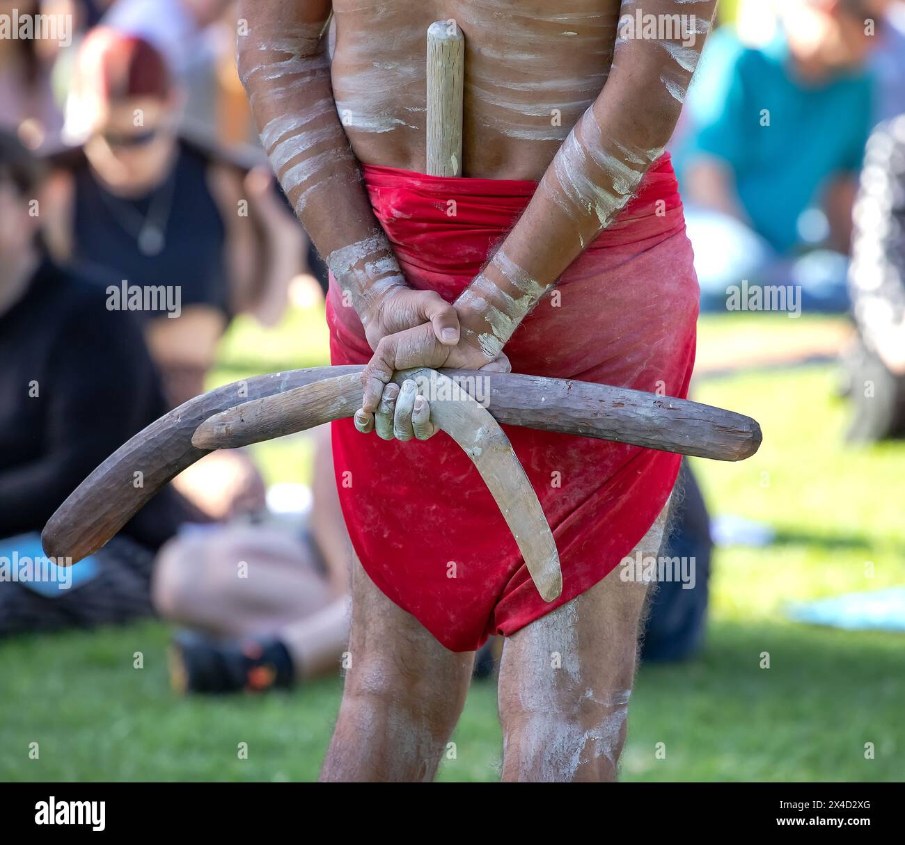 Die menschliche Hand hält rituelle Klappern für den Willkommensritus bei einer indigenen Gemeinde in Australien Stockfoto