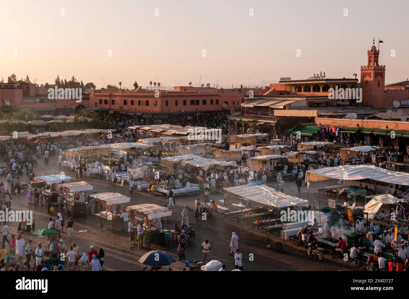 Menschenmassen versammeln sich am Jemaa al Fna Platz bei Sonnenuntergang für die abendlichen Imbissstände. Marrakesch, Marokko. Stockfoto