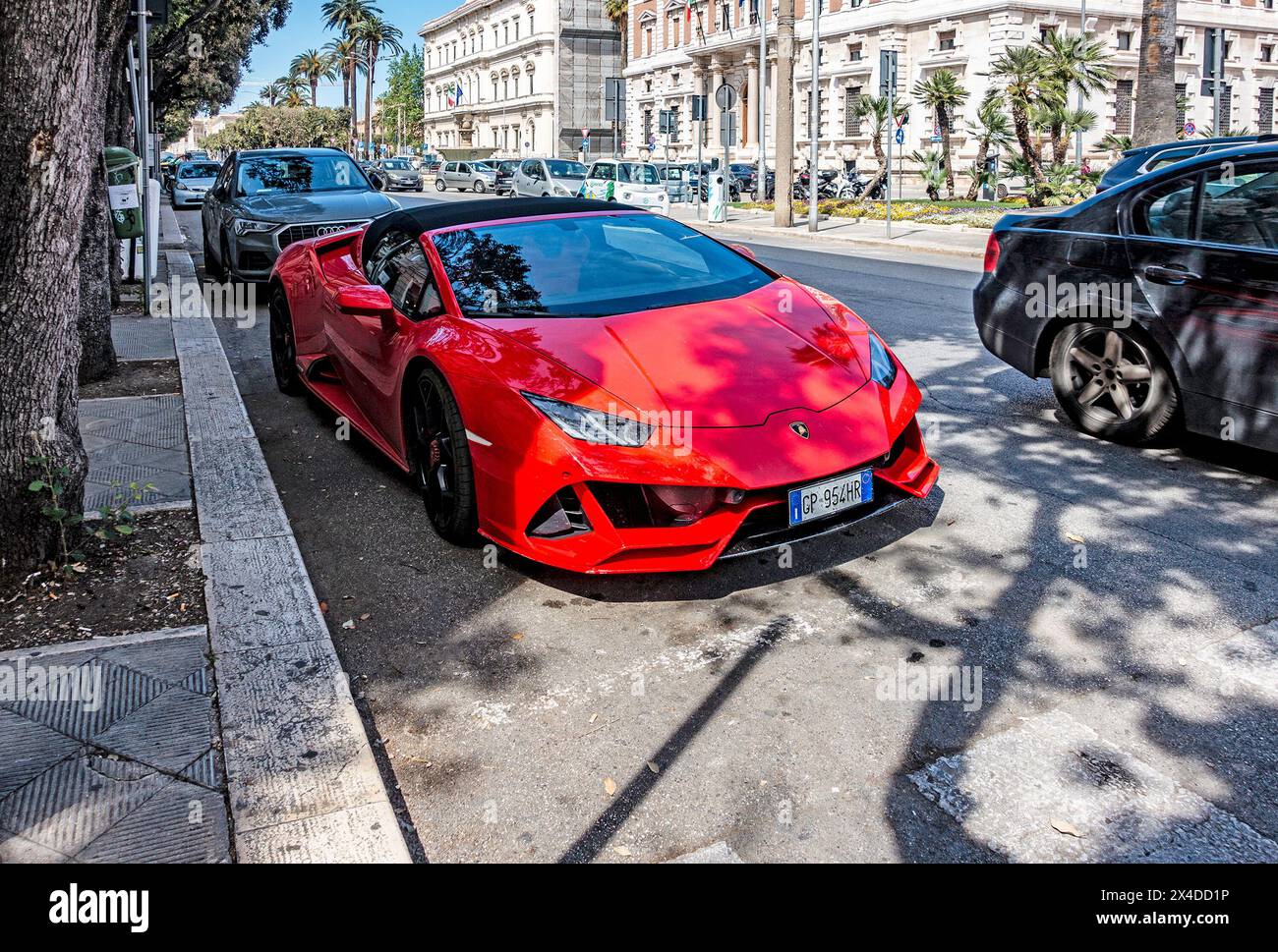 Red Lamborghini Sportwagen parkt entlang einer von Bäumen gesäumten Stadtstraße in Bari, Italien. Stockfoto