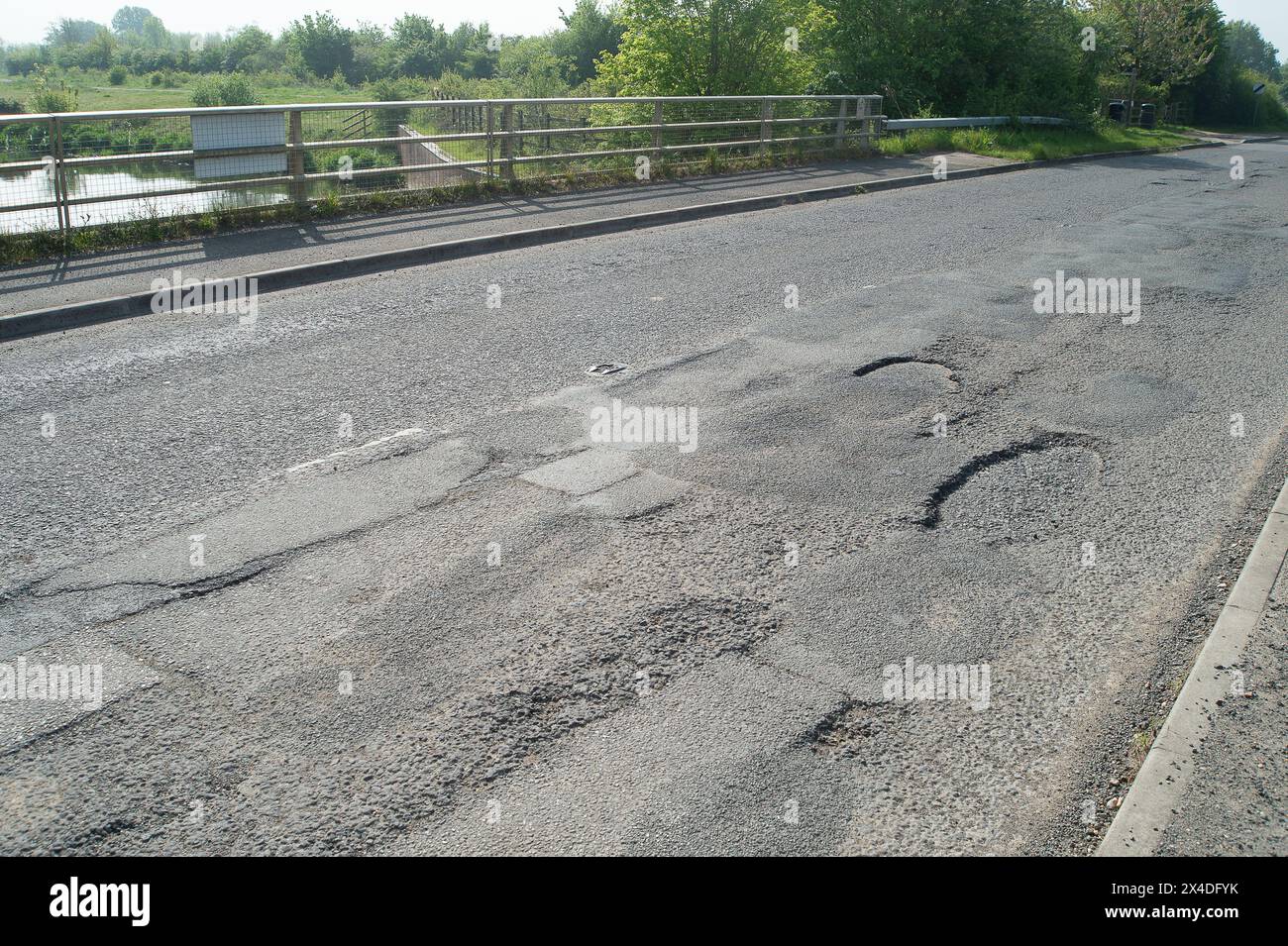 Dorney REACH, Buckinghamshire, Großbritannien. Mai 2024. Schlaglöcher auf einer defekten Straßenoberfläche auf einer Landstraße in Dorney REACH, Buckinghamshire. Die Schlaglöcher wurden im letzten Sommer von Bauunternehmern des Buckinghamshire Council mit einem neuen System gefüllt, die Schlaglöcher sind jedoch zurückgekehrt. Die Straßen von Buckinghamshire werden von Schlaglöchern durchbrochen. Kredit: Maureen McLean/Alamy Stockfoto