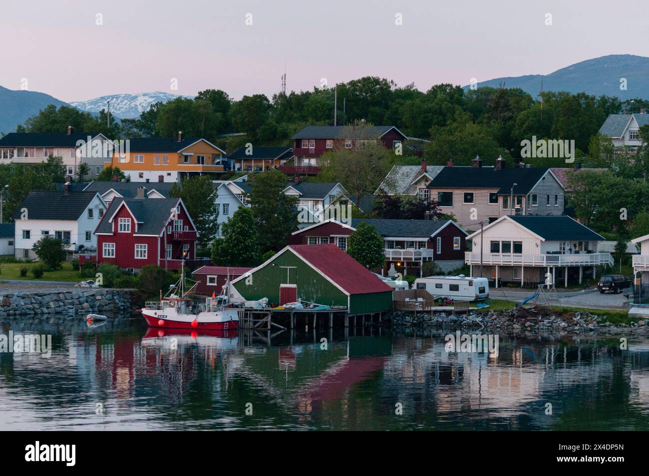Bunt bemalte Häuser in der Küstenstadt Bronnoysund reflektieren den Hafen. Bronnoysund, Bronnoy, Nordland, Norwegen. Stockfoto