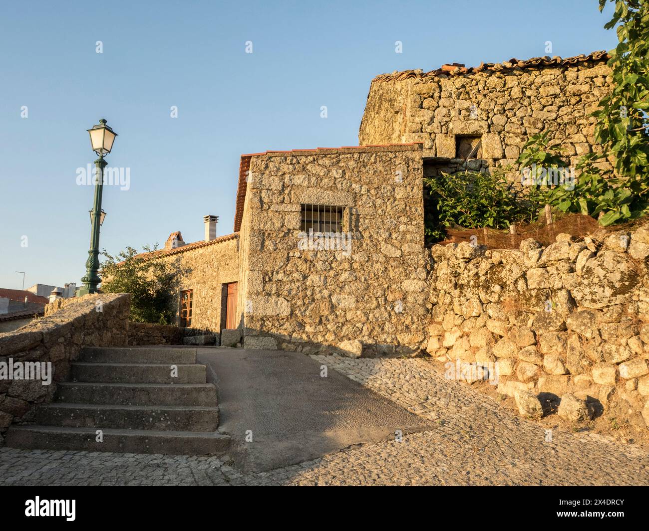 Altes portugiesisches Dorf, das auf der Seite eines Berges zwischen großen Felsbrocken mit Kopfsteinpflasterstraßen und Häusern erbaut wurde. Stockfoto