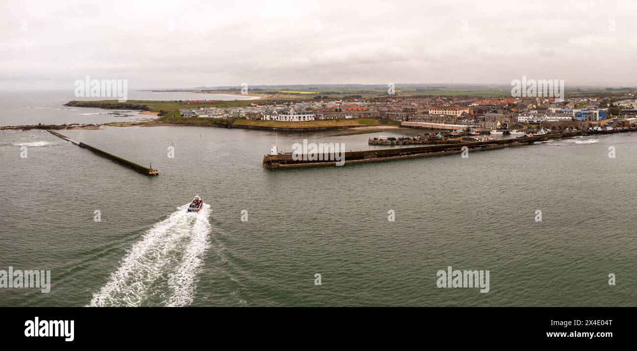 Panoramablick aus der Luft auf eine Touristenschifffahrt auf Farne Island, die zum Hafen von Seahouses in Northumberland, Großbritannien, zurückkehrt Stockfoto