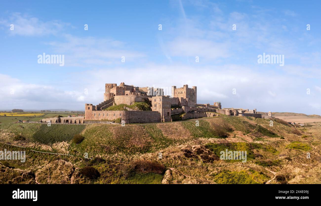 BAMBURGH CASTLE, NORTHUMBERLAND, GROSSBRITANNIEN - 23. APRIL 2024. Panoramablick auf Bamburgh Castle und Sanddünen auf dem wunderschönen Northumberlan Stockfoto