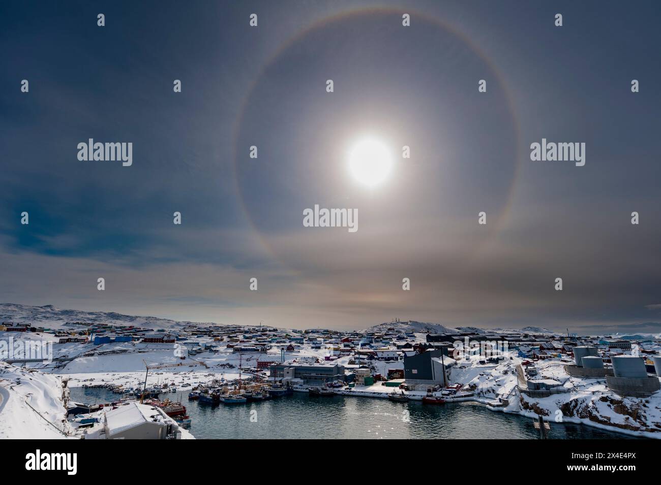 Ein solarer Halo, ein Phänomen, das durch die Wechselwirkung von Licht mit Eiskristallen in der Atmosphäre verursacht wird. Ilulissat, Grönland. Stockfoto