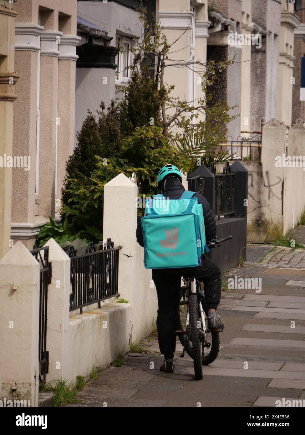 Gig Economy Deliveroo-Fahrer auf der Straße, der auf Bestellungen wartet. Stockfoto