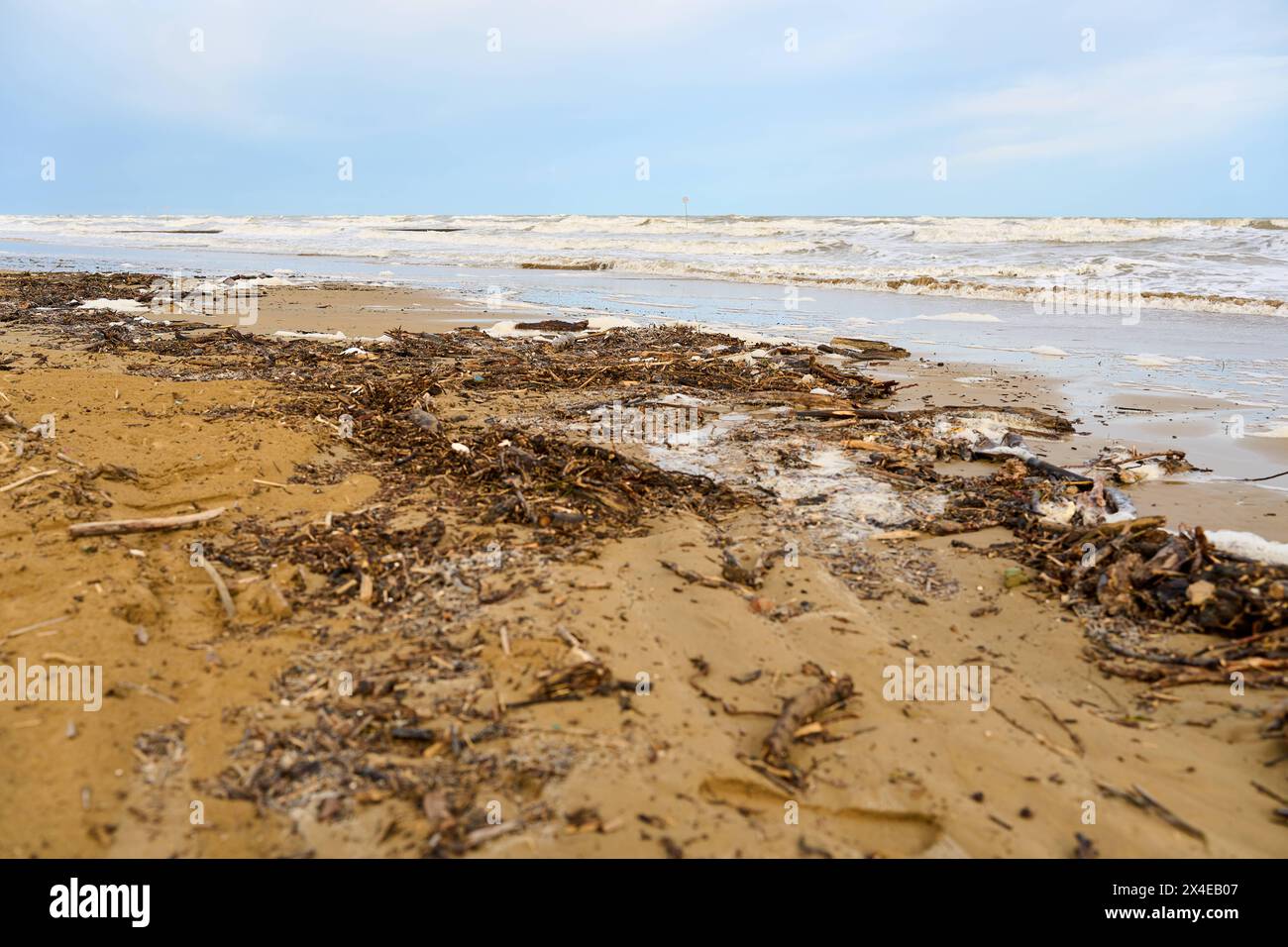 Lido di Jesolo, Italien - 2. Mai 2024: Nach einem Sturm verstreut. Die Wellen haben Holz und Plastik aus dem Meer gespült. Verschmutzungskonzept *** Verschmutzer Strand nach einem Sturm. Die Wellen haben aus dem Meer Treiholz und Plastik angespült. Umweltverschmutzungskonzept Stockfoto