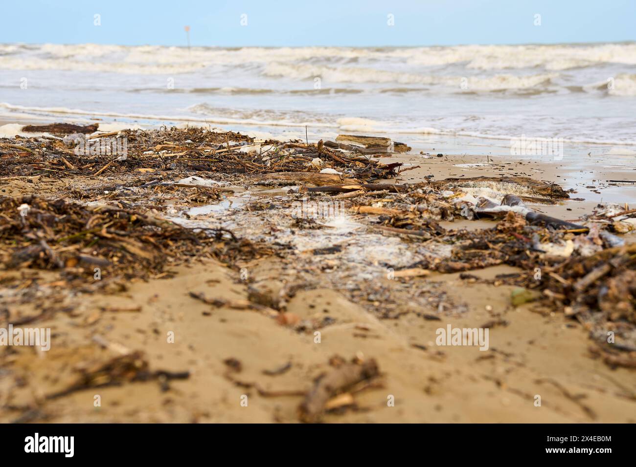 Lido di Jesolo, Italien - 2. Mai 2024: Nach einem Sturm verstreut. Die Wellen haben Holz und Plastik aus dem Meer gespült. Verschmutzungskonzept *** Verschmutzer Strand nach einem Sturm. Die Wellen haben aus dem Meer Treiholz und Plastik angespült. Umweltverschmutzungskonzept Stockfoto