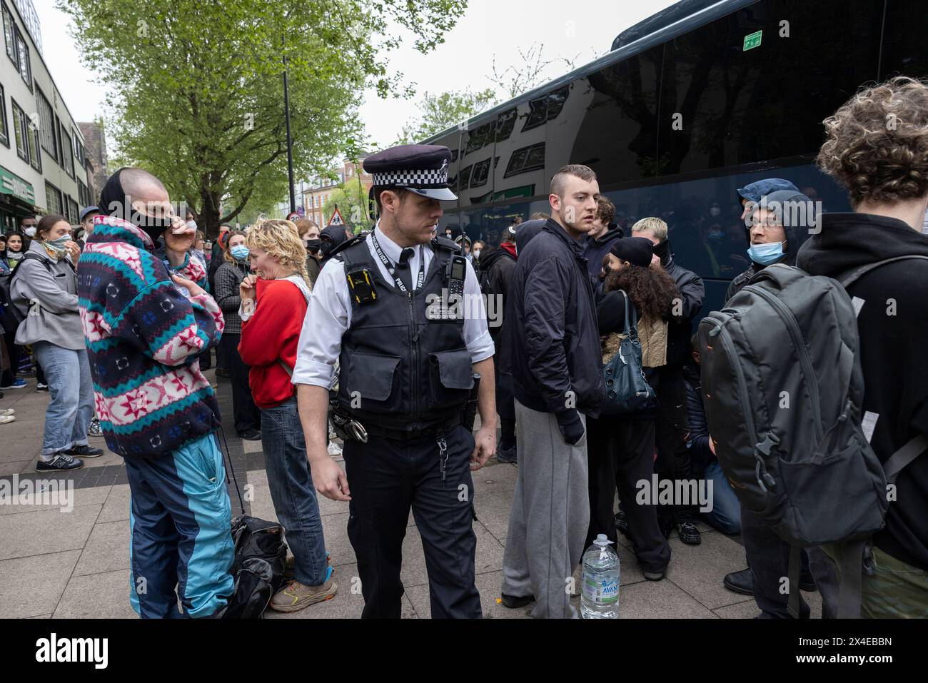 Ein Bus, der Asylsuchende abholen und zu dem von Demonstranten umgebenen Lastkahn Bibby Stockholm in Peckham South London, England, bringen soll Stockfoto