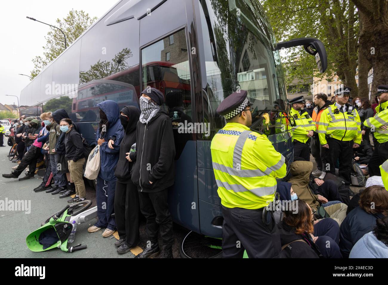 Ein Bus, der Asylsuchende abholen und zu dem von Demonstranten umgebenen Lastkahn Bibby Stockholm in Peckham South London, England, bringen soll Stockfoto