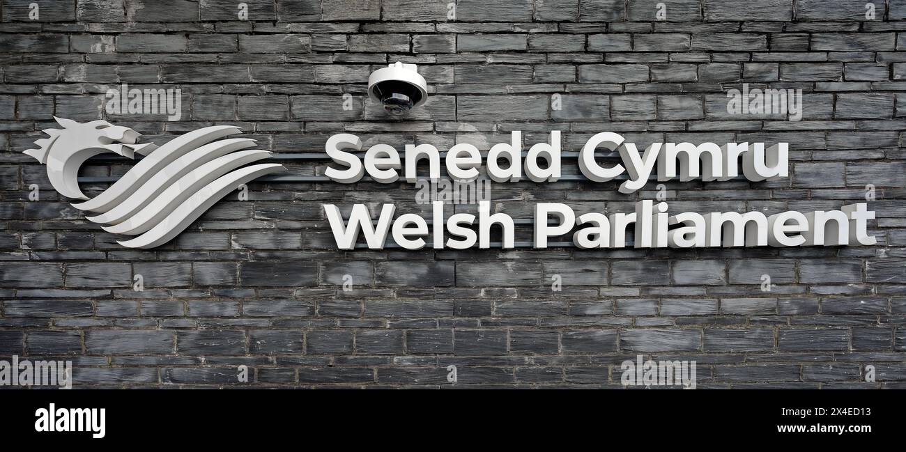 Cardiff Bay Schild auf grauer Schieferwand für das walisische Parlament - Senedd Cymru vor dem walisischen Parlamentsgebäude im Mai 2024 Stockfoto