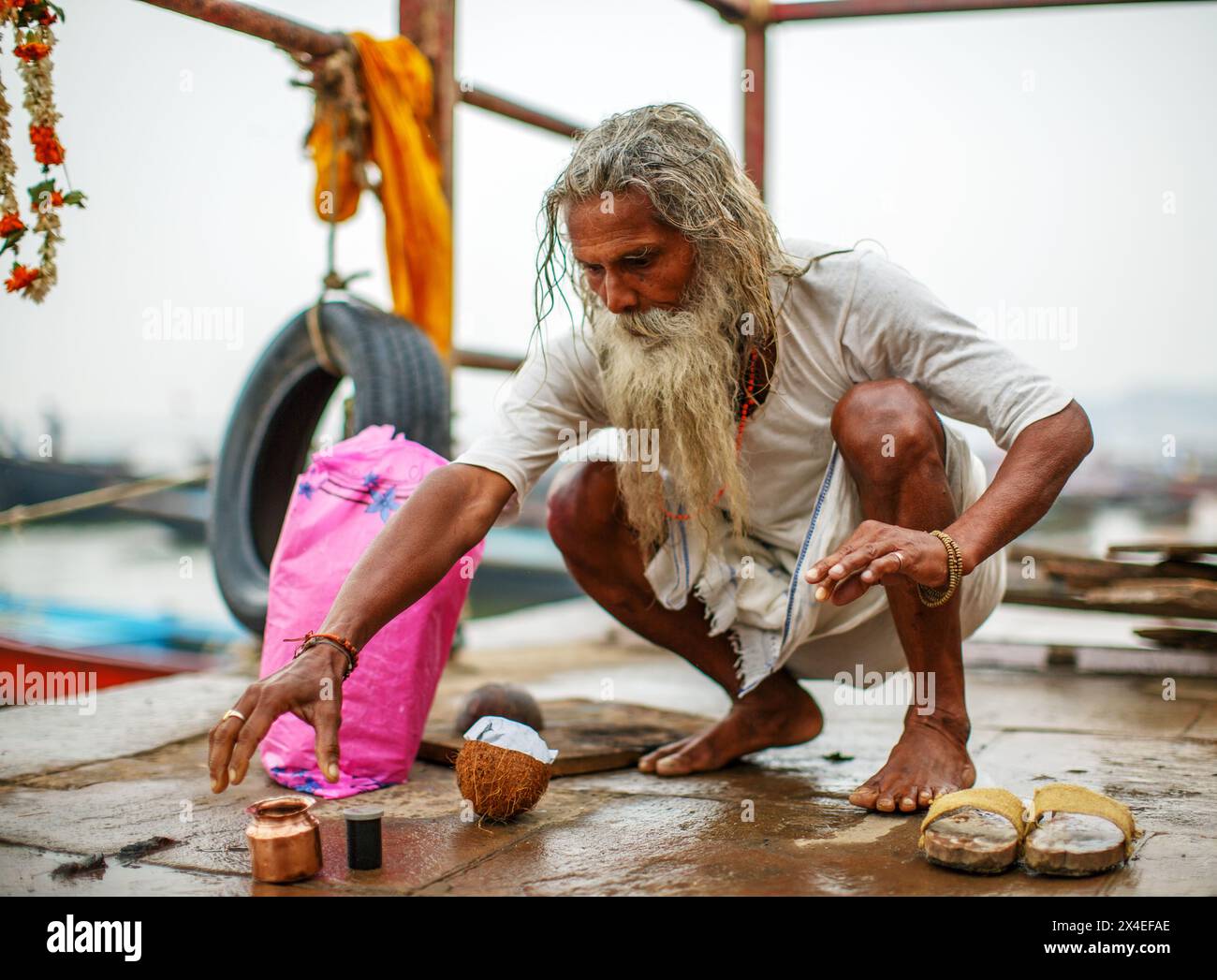 Älterer Mann, der hinduistische Rituale am Ufer des Ganges bei Varanasi, Indien, durchführt. Stockfoto