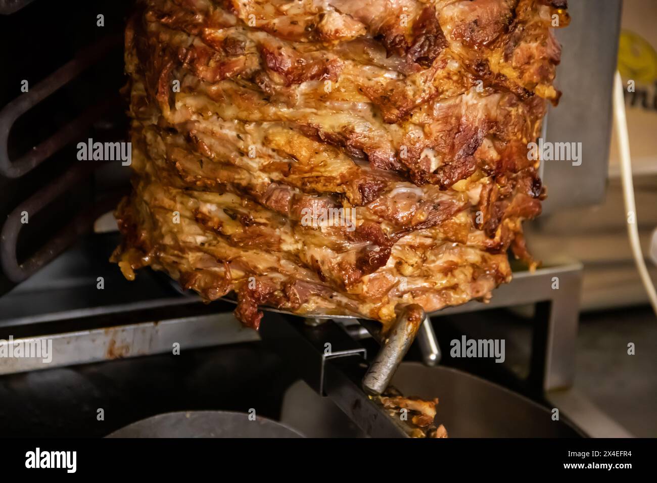 Gyros: Saftige, gewürzte Fleischscheiben, perfekt gegrillt, in eine warme Pita gewickelt, mit frischen Tomaten, Zwiebeln und cremiger Tzatziki-Sauce garniert Stockfoto